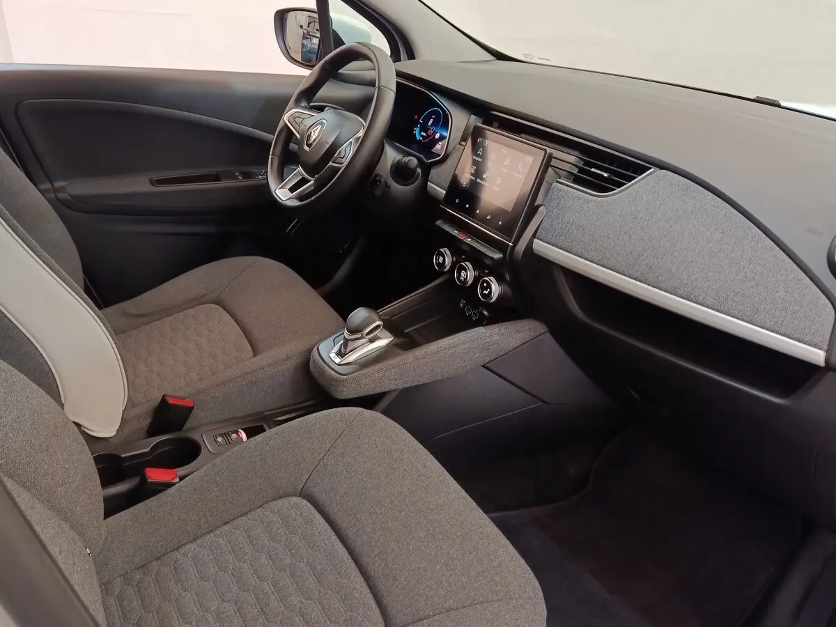Intérieur de la Renault ZOE Zen 2021, vue côté conducteur, volant cuir, écran tactile central et sièges gris.