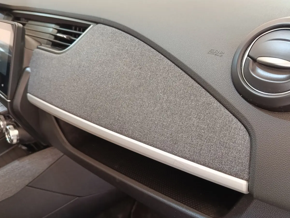 Vue rapprochée de la planche de bord grise et noire de la Renault ZOE Zen R135 2021, avec aérateur rond noir.