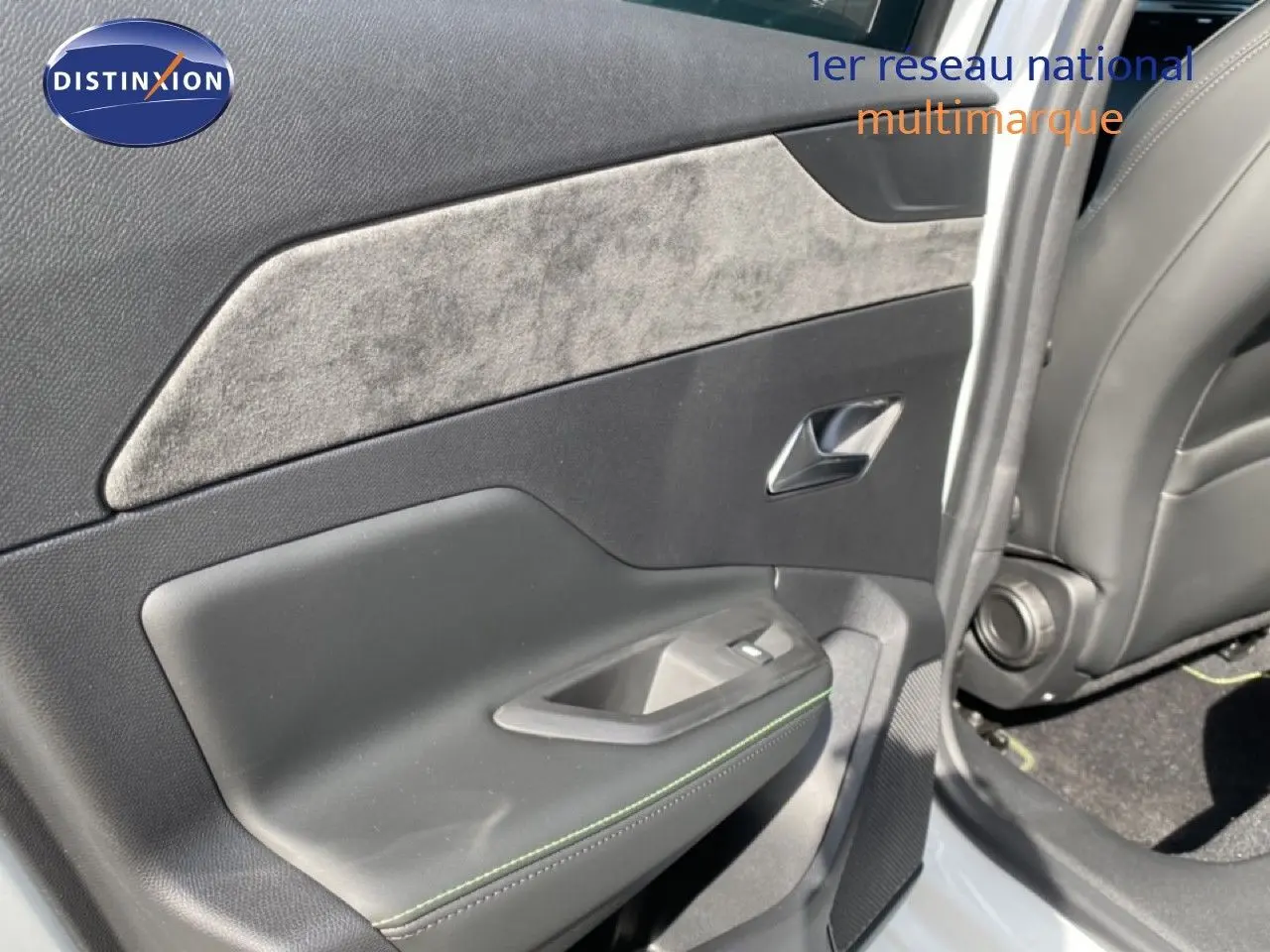 Vue intérieure côté gauche de la porte arrière d'une Peugeot 308 Hybrid blanche avec garniture tissu et cuir noir.