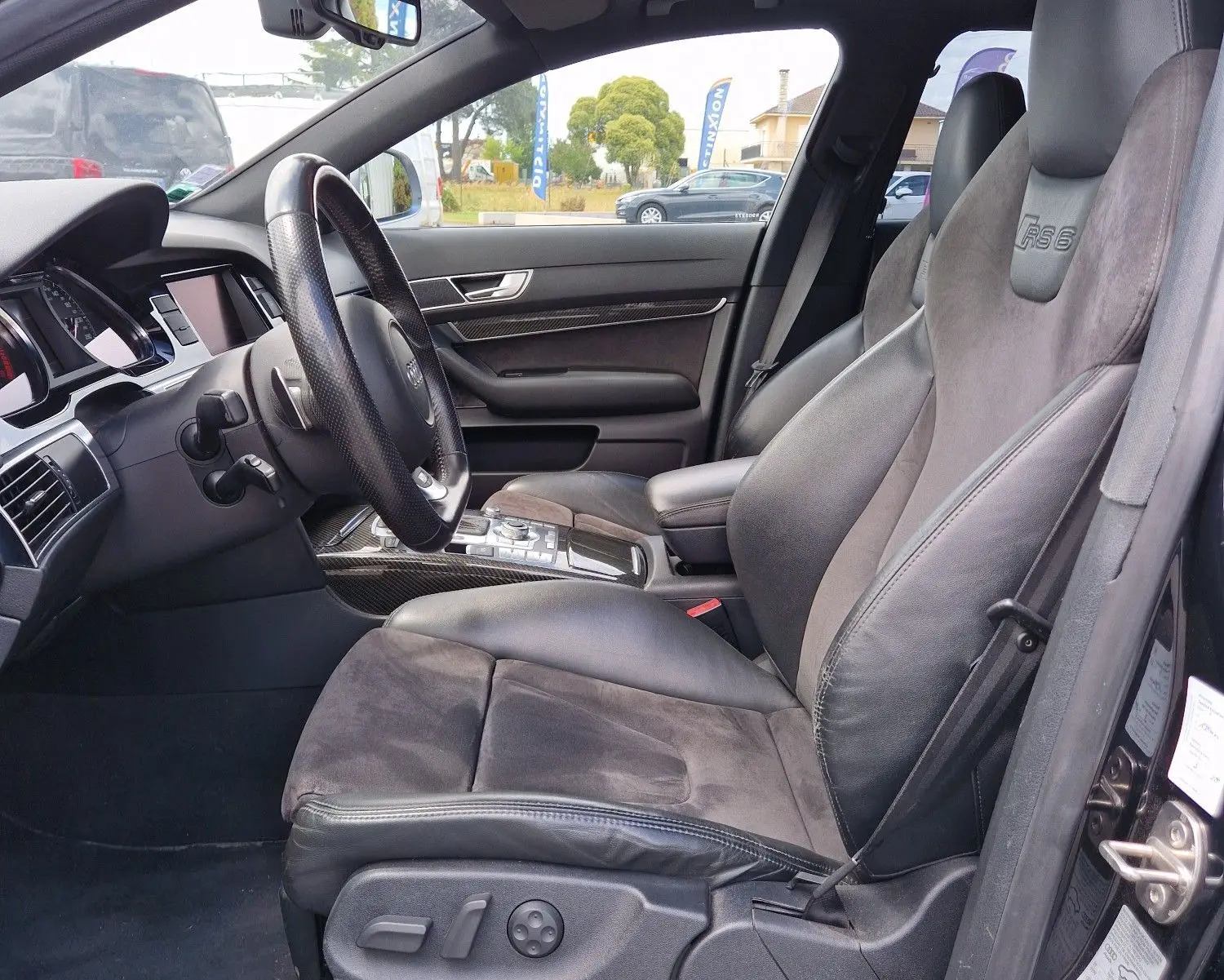 Vue intérieure côté conducteur de l'Audi RS6 Avant noire de 2009, sièges sport en cuir avec logo RS6 embossé.