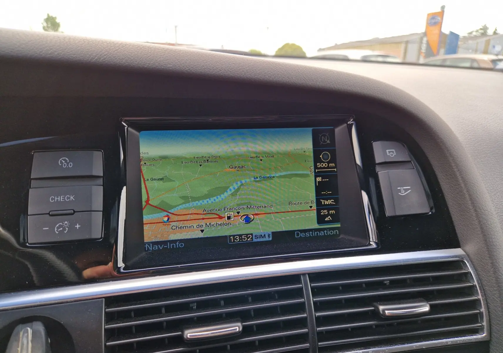 Vue intérieure centrée sur l'écran de navigation du tableau de bord d'une Audi RS6 Avant noire de 2009.