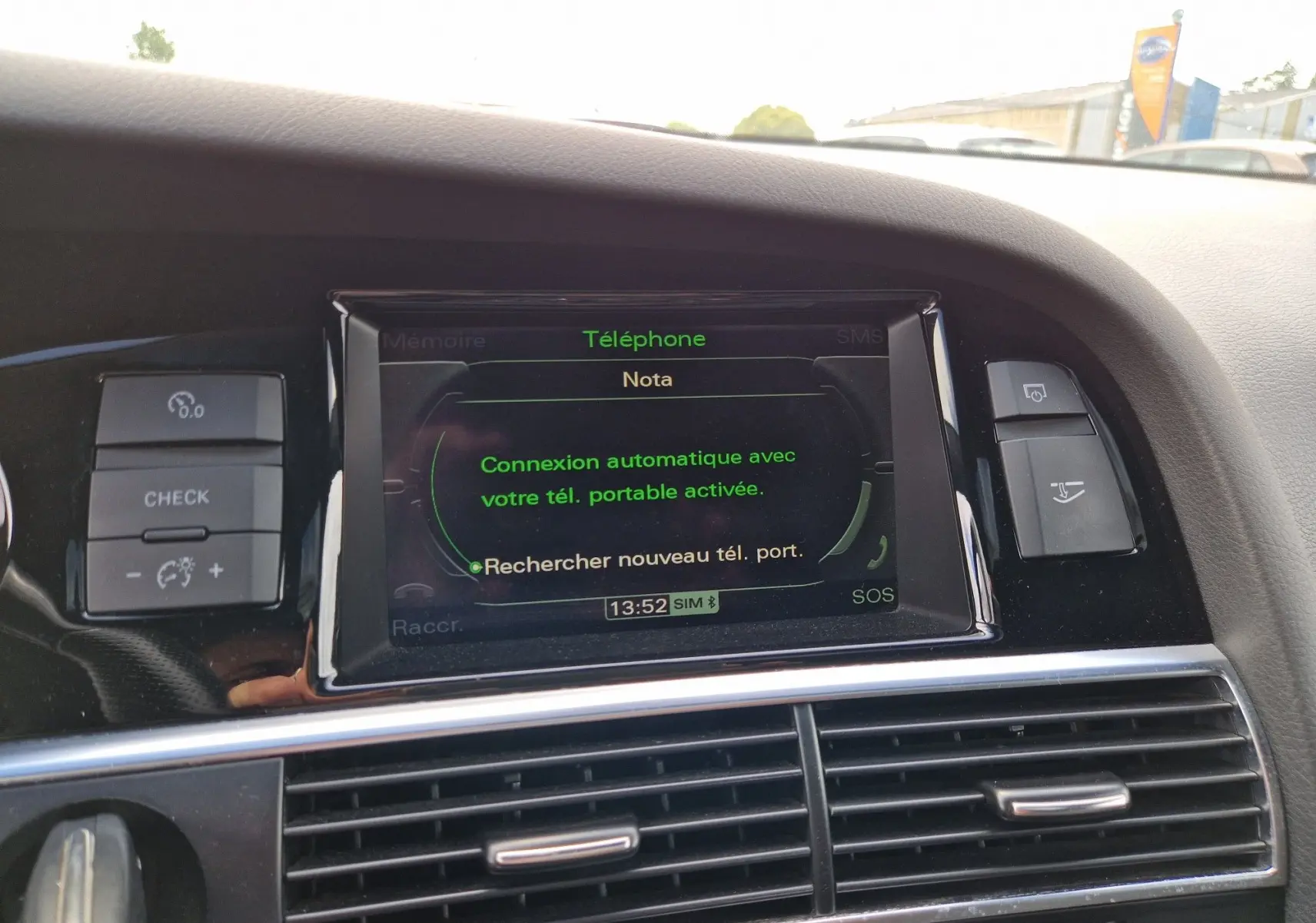 Vue rapprochée de l'écran central noir affichant la connexion Bluetooth dans l'habitacle d'une Audi RS6 Avant noire de 2009.
