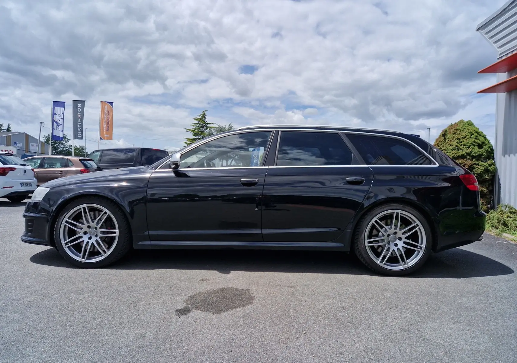 Vue de profil côté gauche d'une Audi RS6 Avant noire de 2009 avec jantes alliage sport et vitres teintées.
