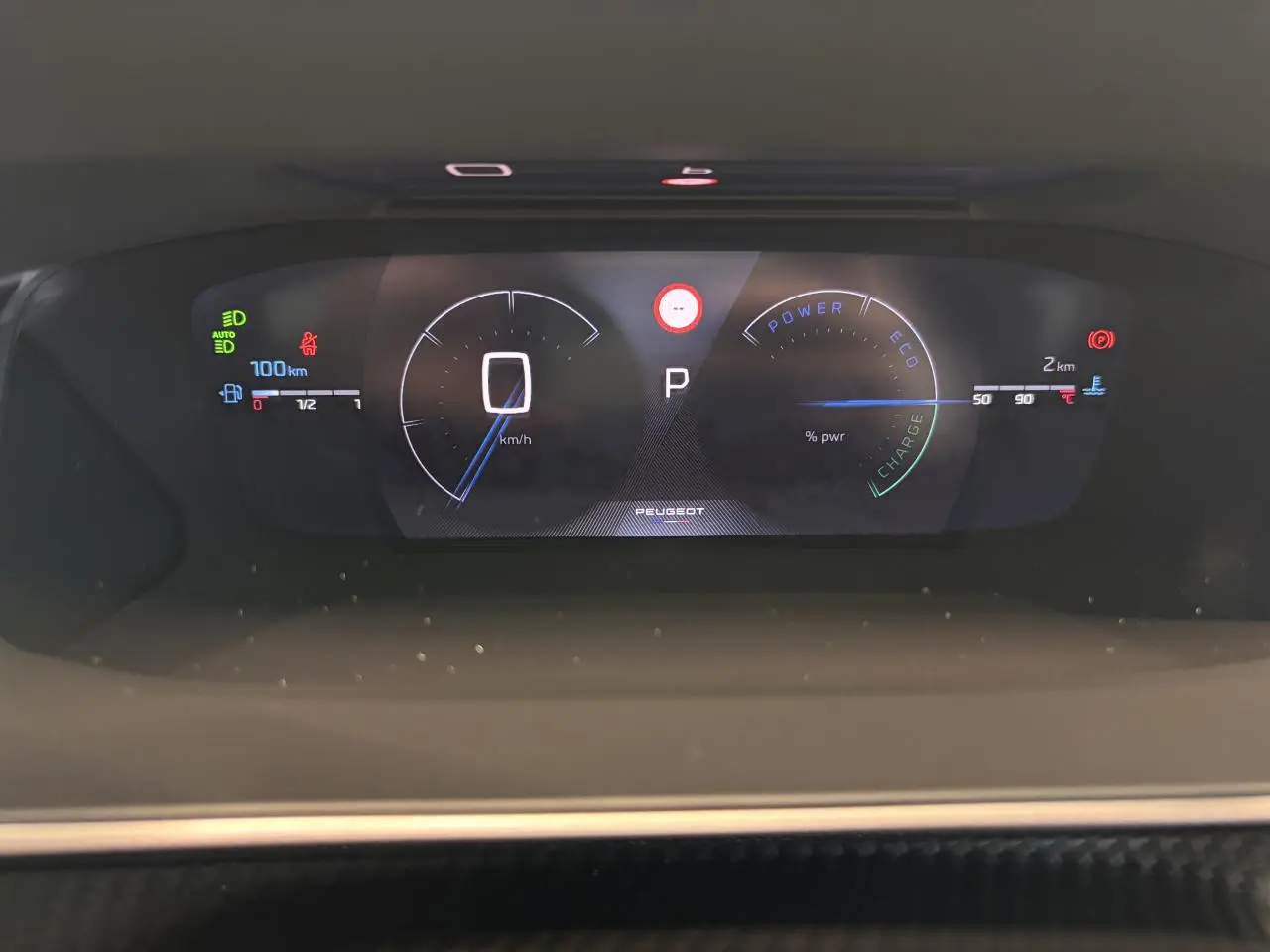 Vue rapprochée du combiné numérique 3D du Peugeot 2008 blanc, affichant vitesse, mode et jauges hybrides.