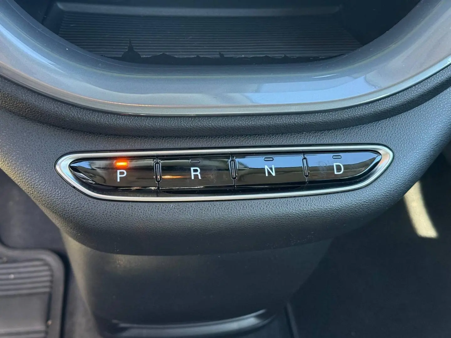 Gros plan sur la commande de boîte automatique de la Fiat 500 e jaune, avec le mode "P" activé, intérieur noir.