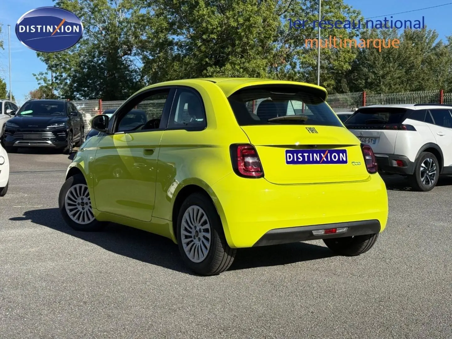 Fiat 500 électrique jaune vue 3/4 arrière droit, avec becquet et feux arrière LED visibles en extérieur.