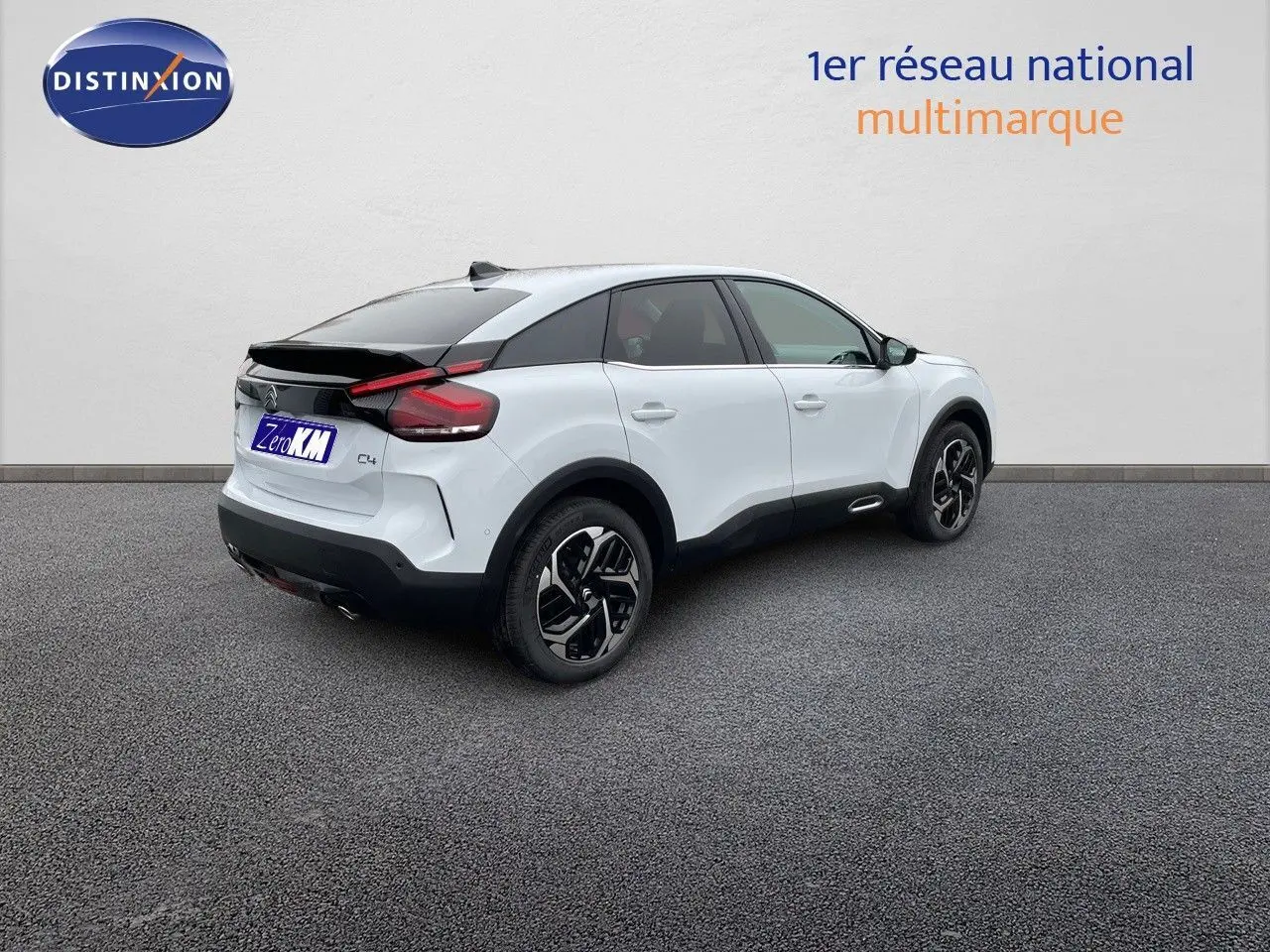 Citroën C4 blanc métal vue 3/4 arrière droit, avec toit noir et jantes noires bicolores.