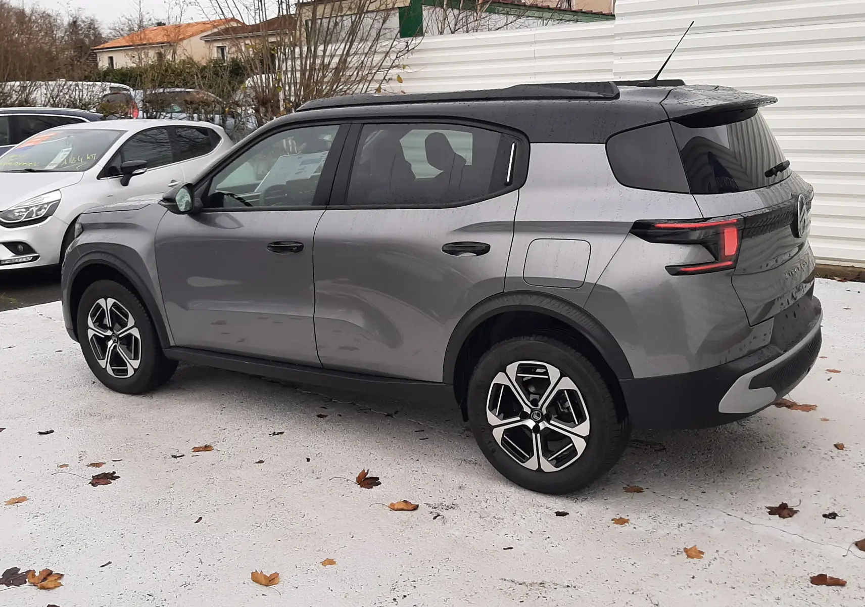 Vue 3/4 arrière droite d'un Citroën C3 Aircross gris Mercury avec toit noir et jantes alliage biton.
