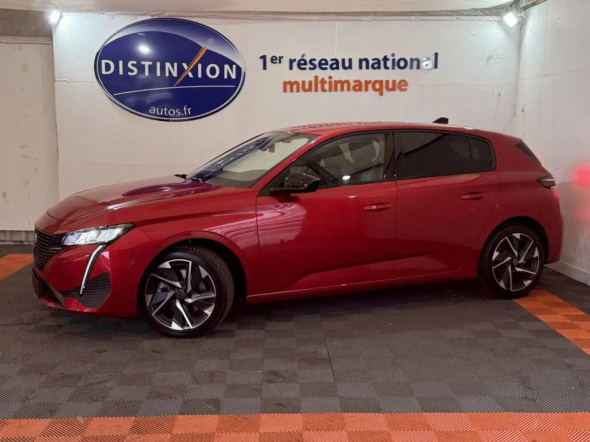 Peugeot 308 BlueHDi 130 AUTO8 Allure rouge vue de profil côté gauche en intérieur avec jantes alliage distinctives.
