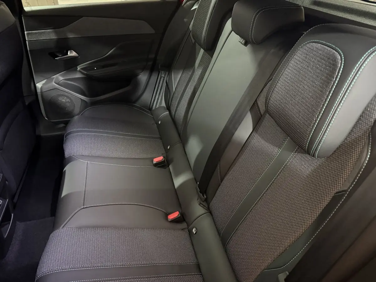 Vue intérieure côté droit montrant la banquette arrière noire avec surpiqûres contrastantes du Peugeot 308 2025.