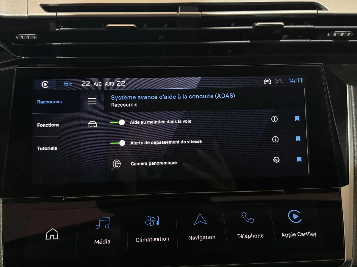 Écran tactile central de la Peugeot 308 rouge, affichant les aides à la conduite avancées, vue intérieure frontale.