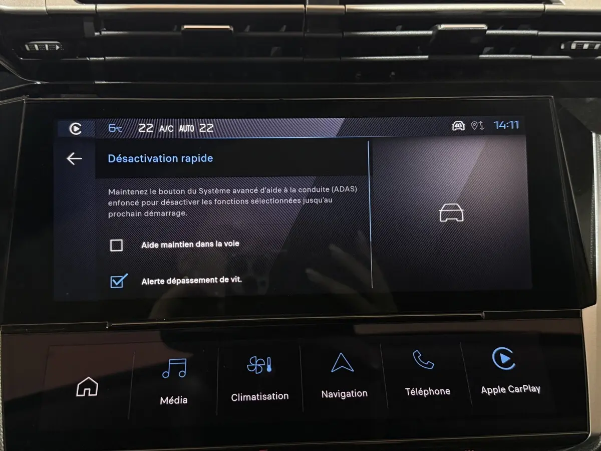 Écran tactile central de la Peugeot 308 rouge, affichant les options d'aide à la conduite et climatisation.