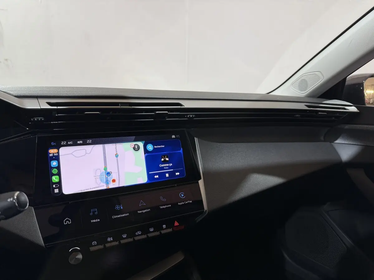 Vue intérieure du tableau de bord de la Peugeot 308 2025 avec écran tactile central affichant une navigation et interface multimédia.