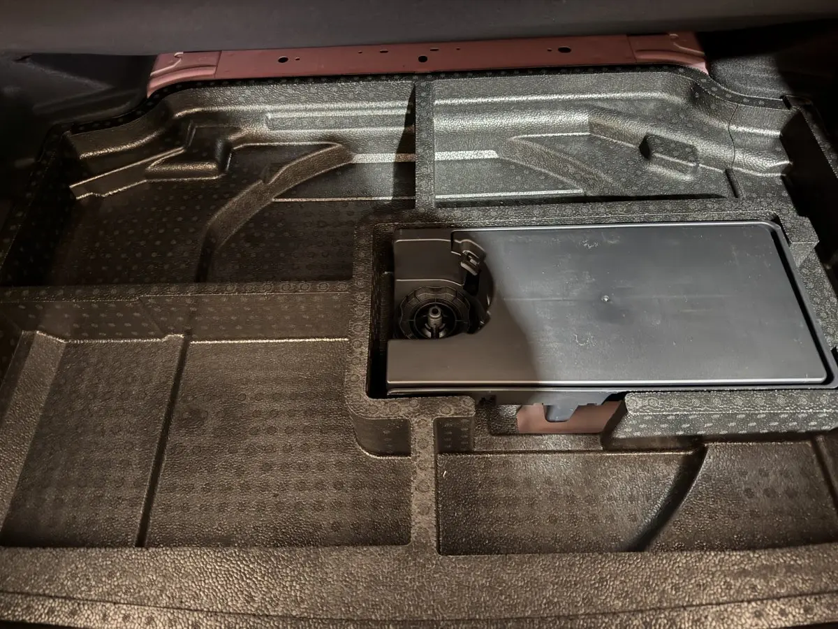 Vue rapprochée du rangement sous tablette dans le coffre de la Peugeot 308 rouge 2025 BlueHDi 130 AUTO8 ALLURE.