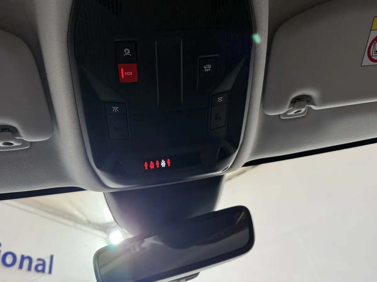Vue intérieure du plafond avant de la Peugeot 308 rouge, avec commandes SOS et éclairage au-dessus du rétroviseur central.