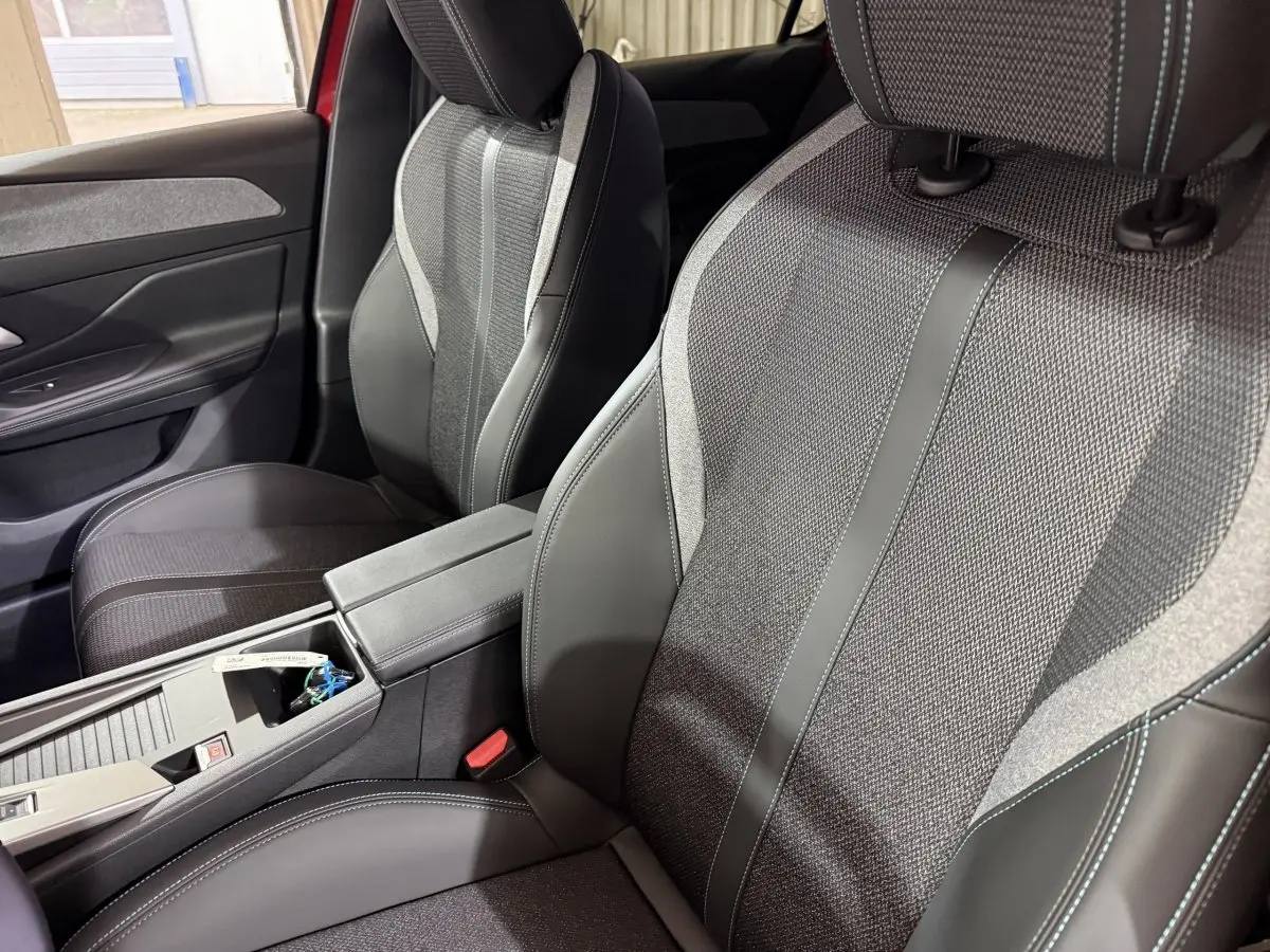 Vue rapprochée des sièges avant en tissu et cuir gris de la Peugeot 308 BlueHDi 130 AUTO8 ALLURE 2025.