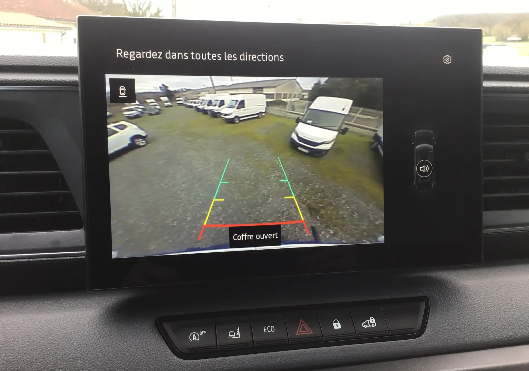 Écran de caméra de recul du Renault Master blanc 2025 montrant l’arrière avec plusieurs fourgons stationnés.