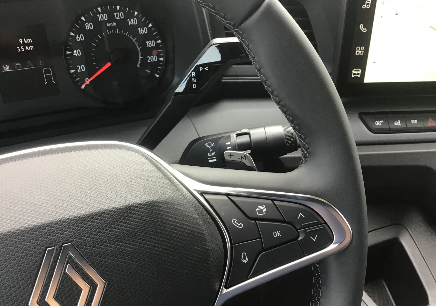 Gros plan sur le volant noir du Renault Master 2025 avec commandes intégrées et tableau de bord digital partiel visible.