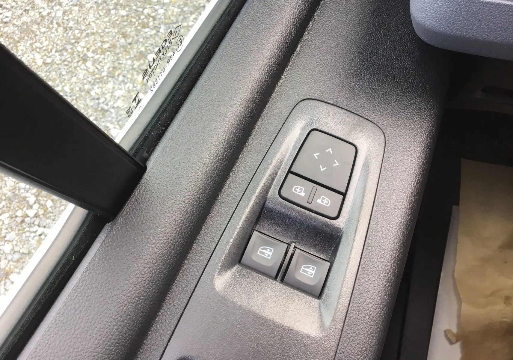 Gros plan sur les commandes électriques des vitres et rétroviseurs côté gauche du Renault Master blanc 2025.