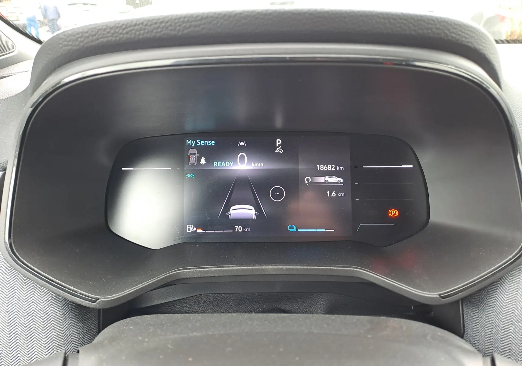 Tableau de bord numérique de la Renault Clio V hybride, affichant l'interface de conduite et l'autonomie.