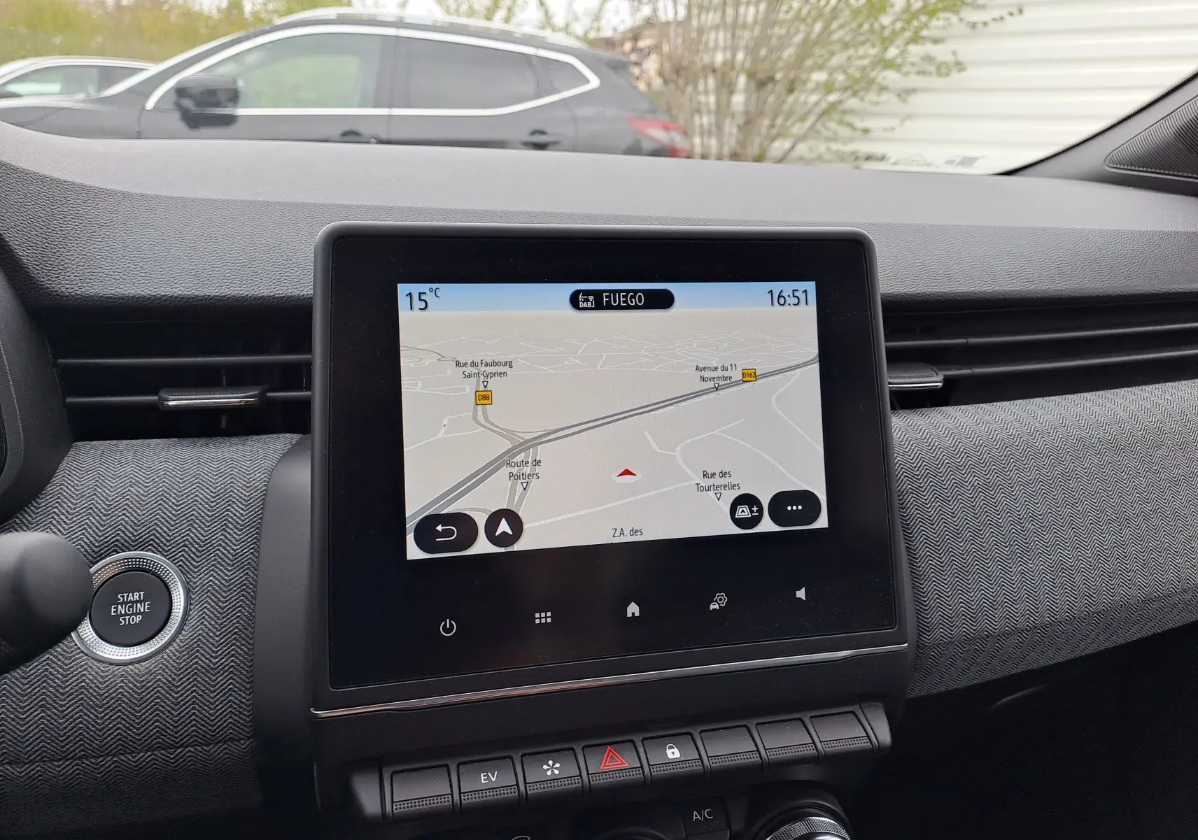 Vue intérieure centrée sur l'écran tactile du tableau de bord de la Renault Clio V, affichant la navigation GPS.