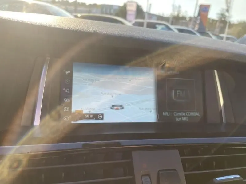 Écran de navigation et radio intérieur du BMW X4 30DA X DRIVE noir métal, vue frontale du tableau de bord.