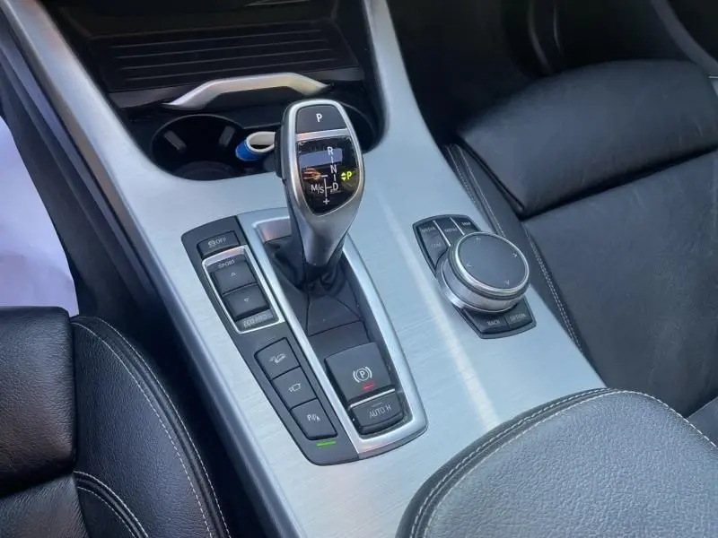 Gros plan sur la console centrale argentée du BMW X4 30DA M Sport 2016 avec levier de vitesses automatique et commandes noires.