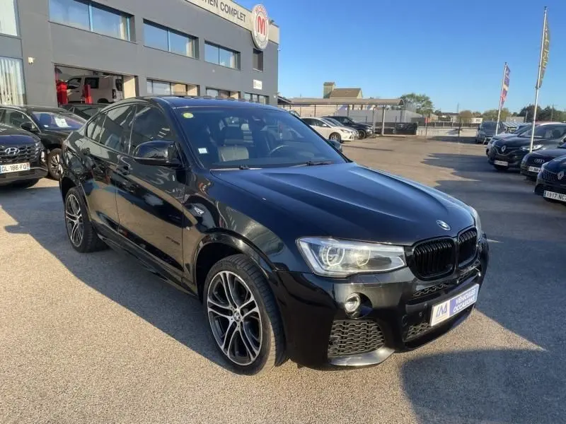 BMW X4 30DA X DRIVE noir métal vue 3/4 avant avec jantes M Sport et calandre noire brillante.