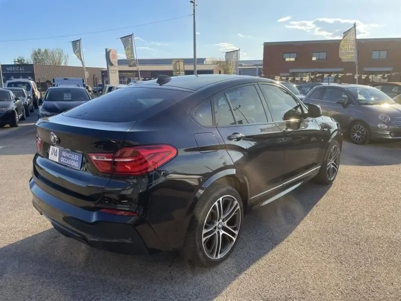 BMW X4 30DA X DRIVE noir métal en 3/4 arrière droit, soulignant ses lignes dynamiques et ses jantes M Sport.