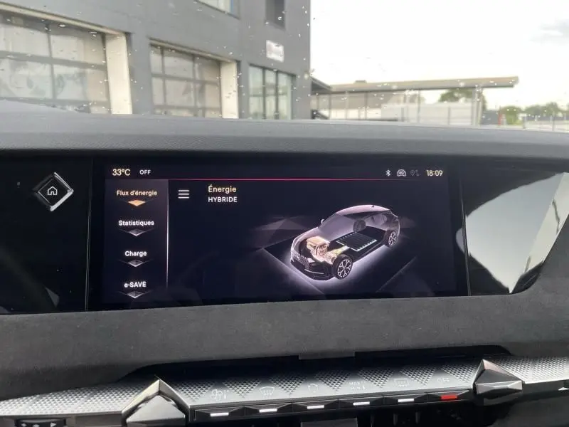 Écran tactile intérieur du DS4 2023 montrant le schéma énergétique hybride du véhicule en gris.