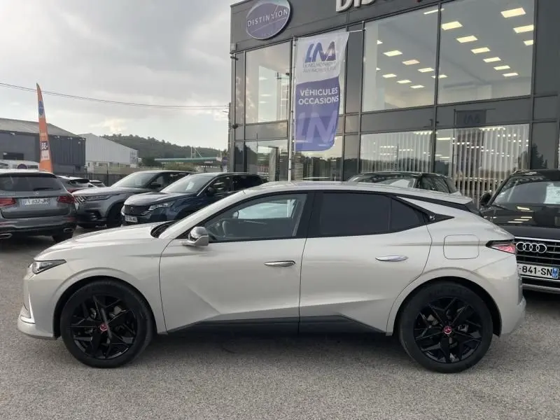 Vue de profil côté gauche d'une DS4 gris clair hybride rechargeable avec jantes noires et lignes anguleuses marquées.