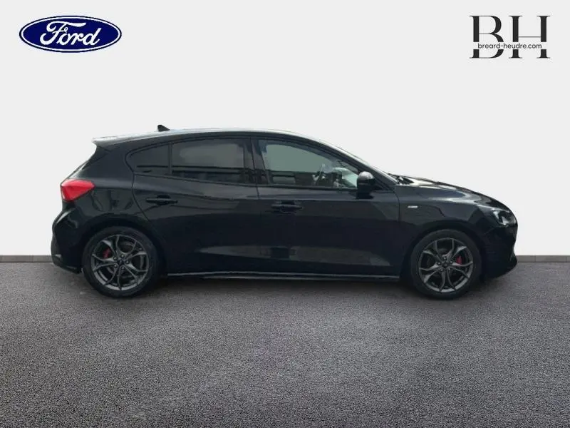 Profil droit d'une Ford Focus 1.0 EcoBoost 125ch ST-Line noire Shadow avec vitres arrière surteintées et jantes alliage.