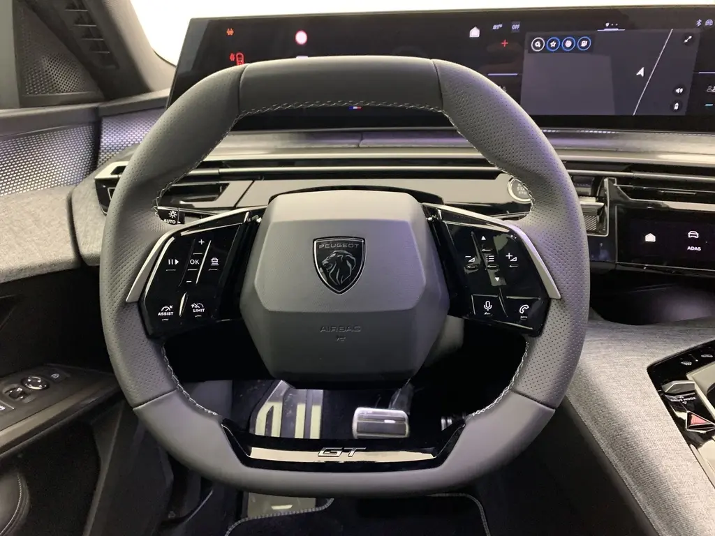 Volant compact cuir noir perforé avec badge GT et tableau de bord numérique du Peugeot 3008 Hybrid 2025, vue de face intérieure.