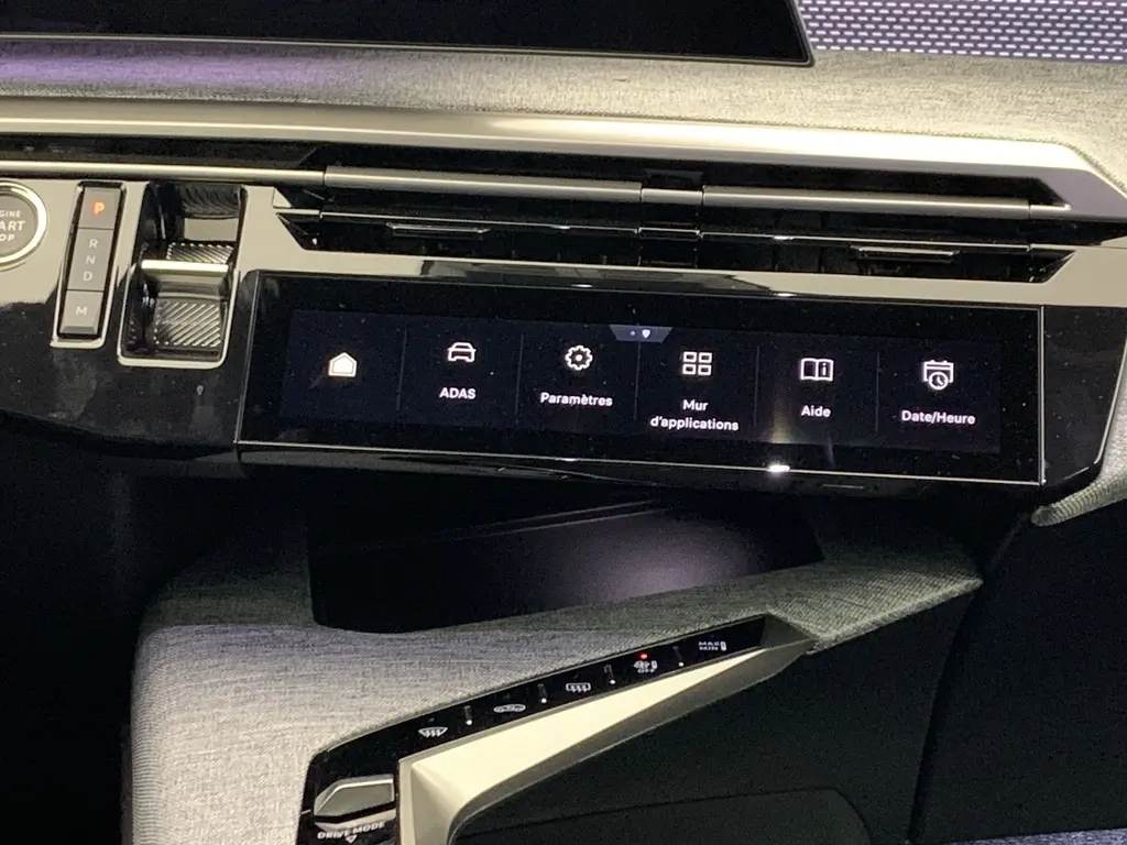 Vue rapprochée de la console centrale noire laquée avec écran tactile et commandes du Peugeot 3008 Hybrid 2025.