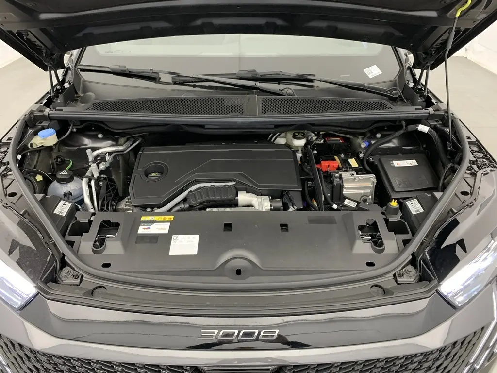 Vue de dessus du compartiment moteur ouvert du Peugeot 3008 Hybrid 145 CH e-DCS6 GT gris titane avec logo 3008 visible sur la calandre noire.