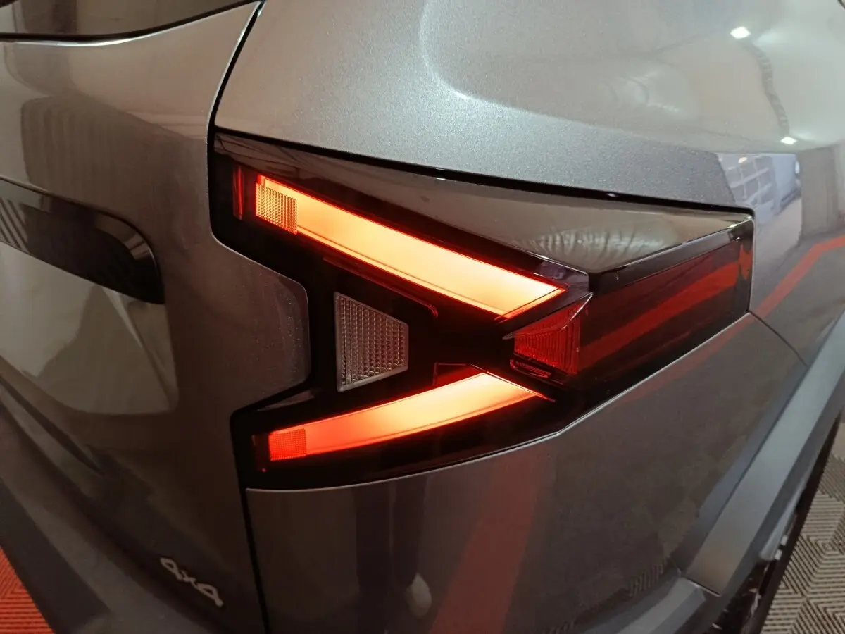 Gros plan sur le feu arrière droit allumé du Dacia Bigster gris foncé 2025 avec logo 4x4 visible.