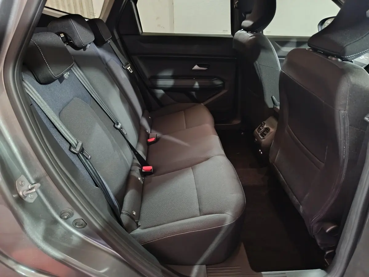 Vue intérieure côté gauche sur la banquette arrière noire du Dacia Bigster gris foncé, avec ceintures et appuie-têtes visibles.