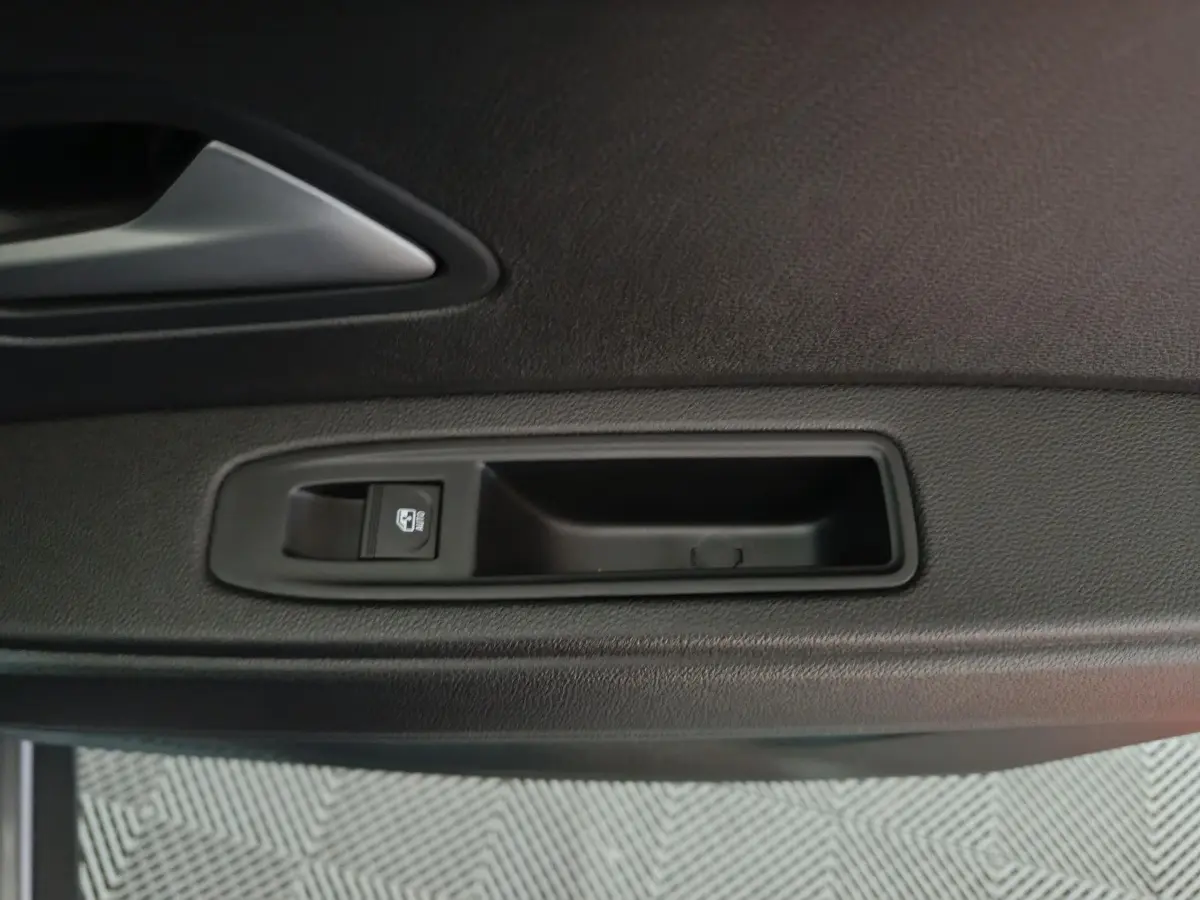 Détail de la poignée intérieure côté gauche de la porte d'une Dacia Bigster gris foncé, avec bouton de verrouillage.