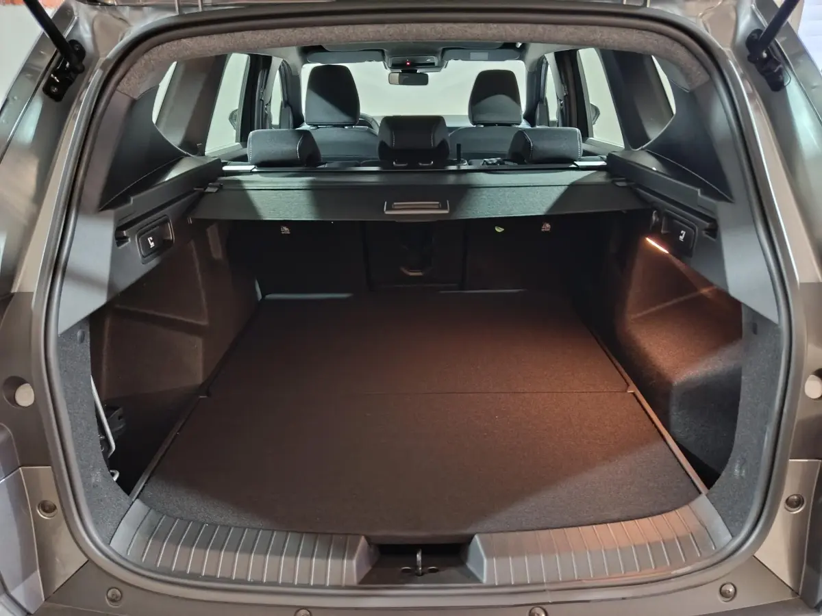 Vue arrière du coffre gris foncé du Dacia Bigster 2025, banquette arrière et cache-bagages visibles.