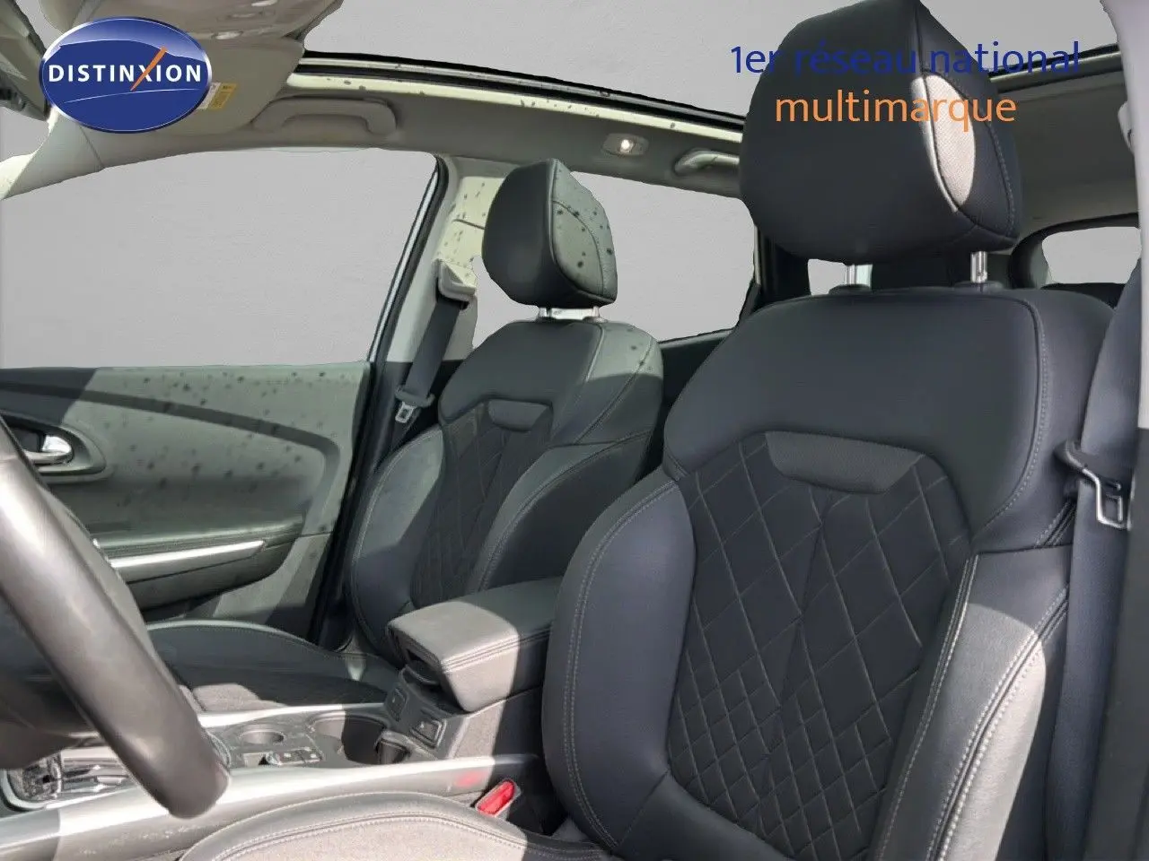 Vue intérieure sur les sièges avant en cuir noir avec surpiqûres losanges du Renault Kadjar 2019, toit ouvrant visible.