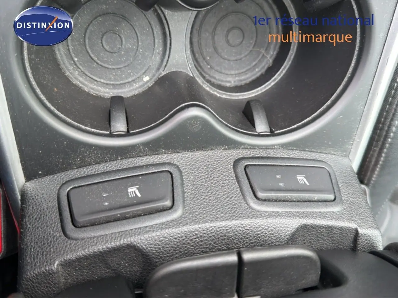 Gros plan sur les boutons de sièges chauffants noirs et porte-gobelets dans l’habitacle du Renault Kadjar gris Highland.