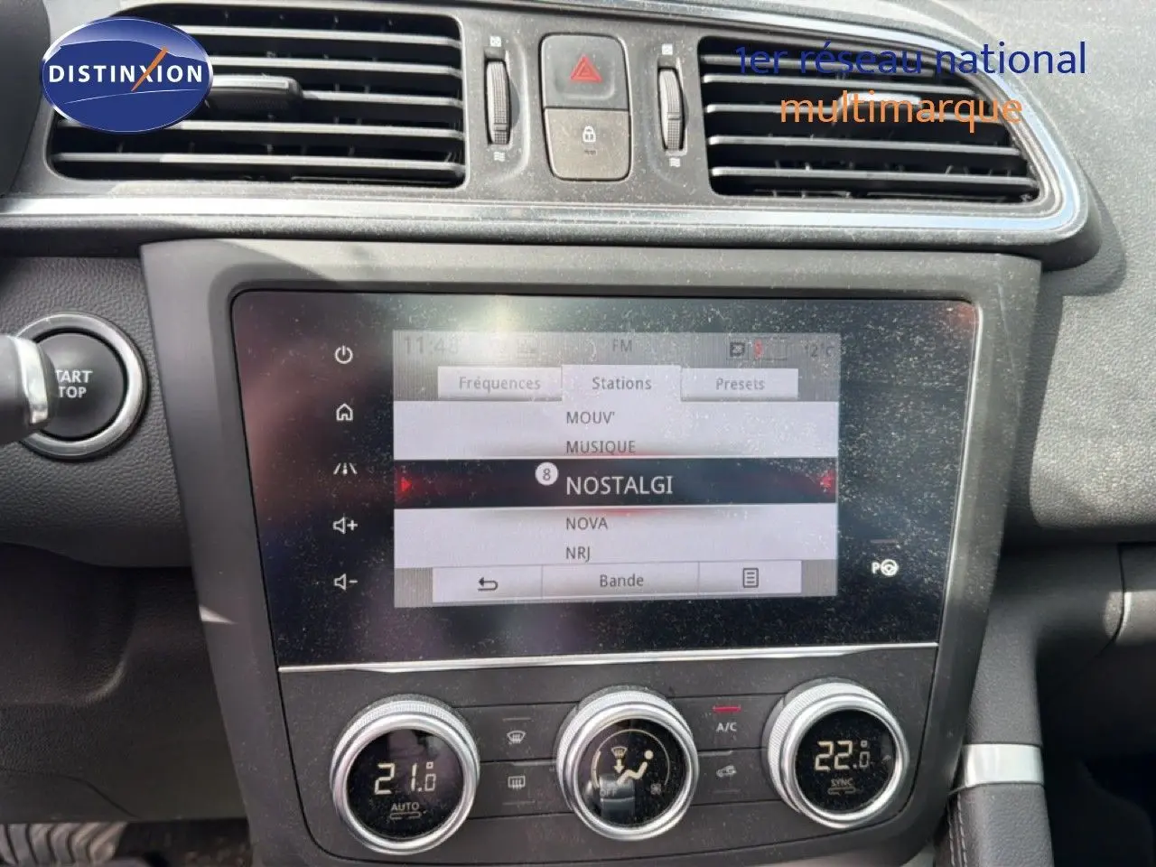 Vue rapprochée de la console centrale du Renault Kadjar gris Highland, avec écran tactile et commandes de climatisation.