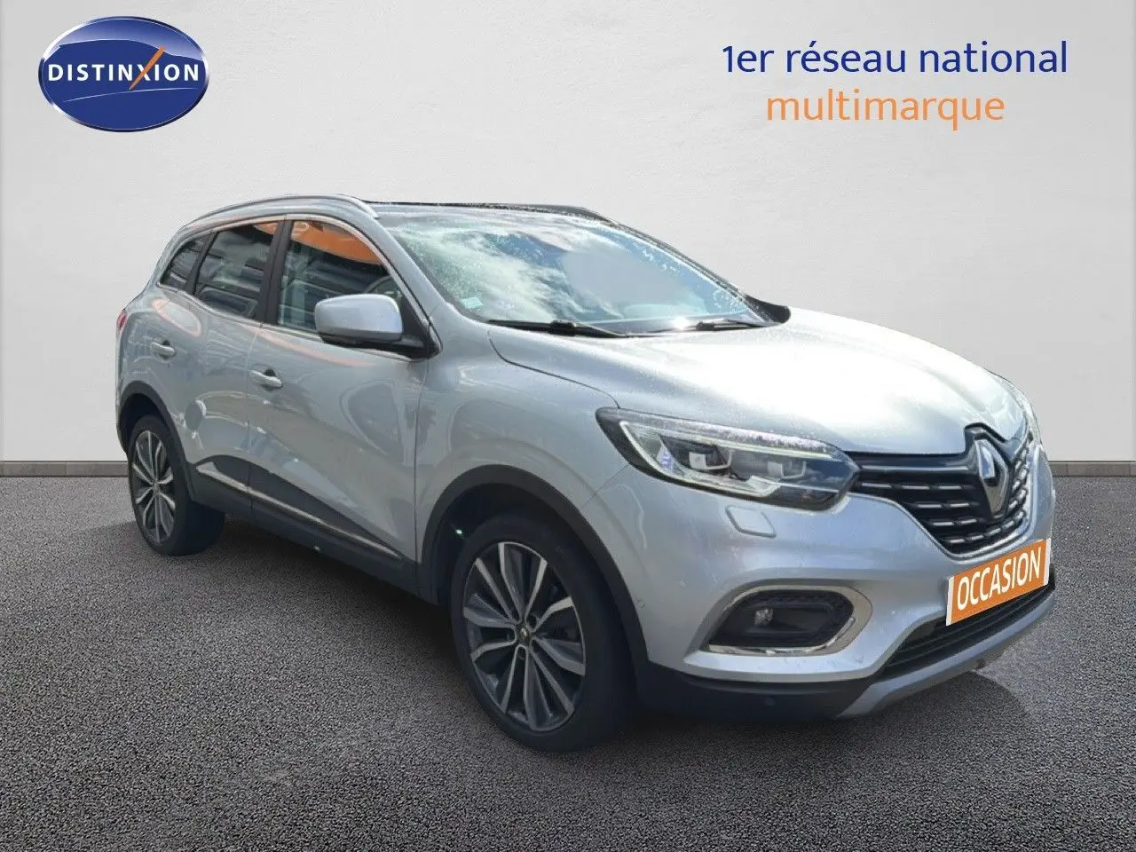 Renault Kadjar gris Highland en 3/4 avant droit, SUV compact avec jantes alliage et calandre noire distinctive.