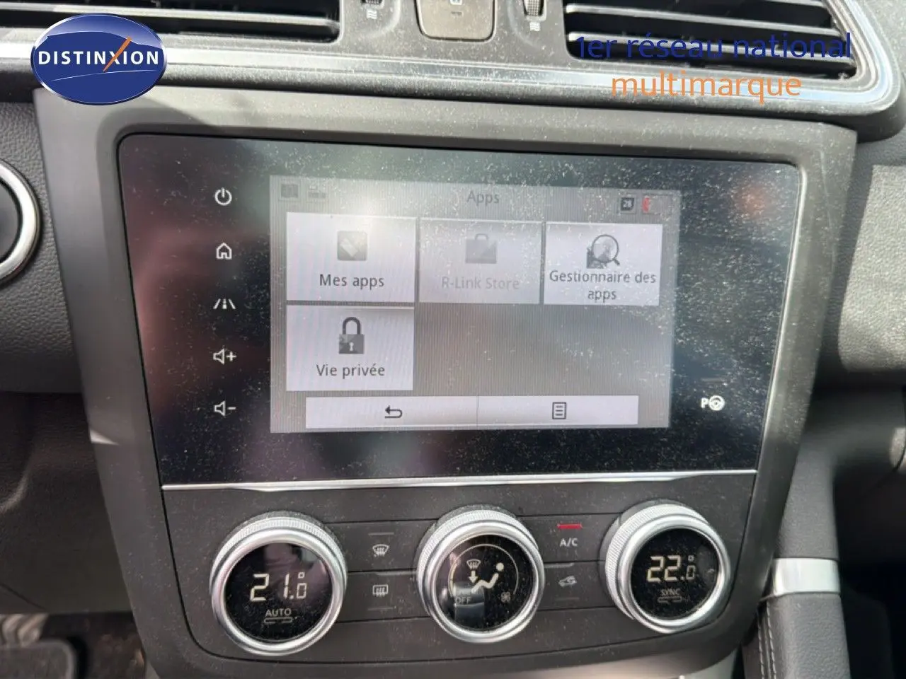 Gros plan sur l’écran tactile et la console centrale du Renault Kadjar gris Highland, affichant la climatisation et les réglages multimédias.