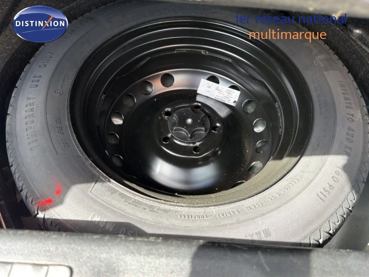 Gros plan sur la roue de secours noire dans le coffre d'un Renault Kadjar gris Highland 2019.