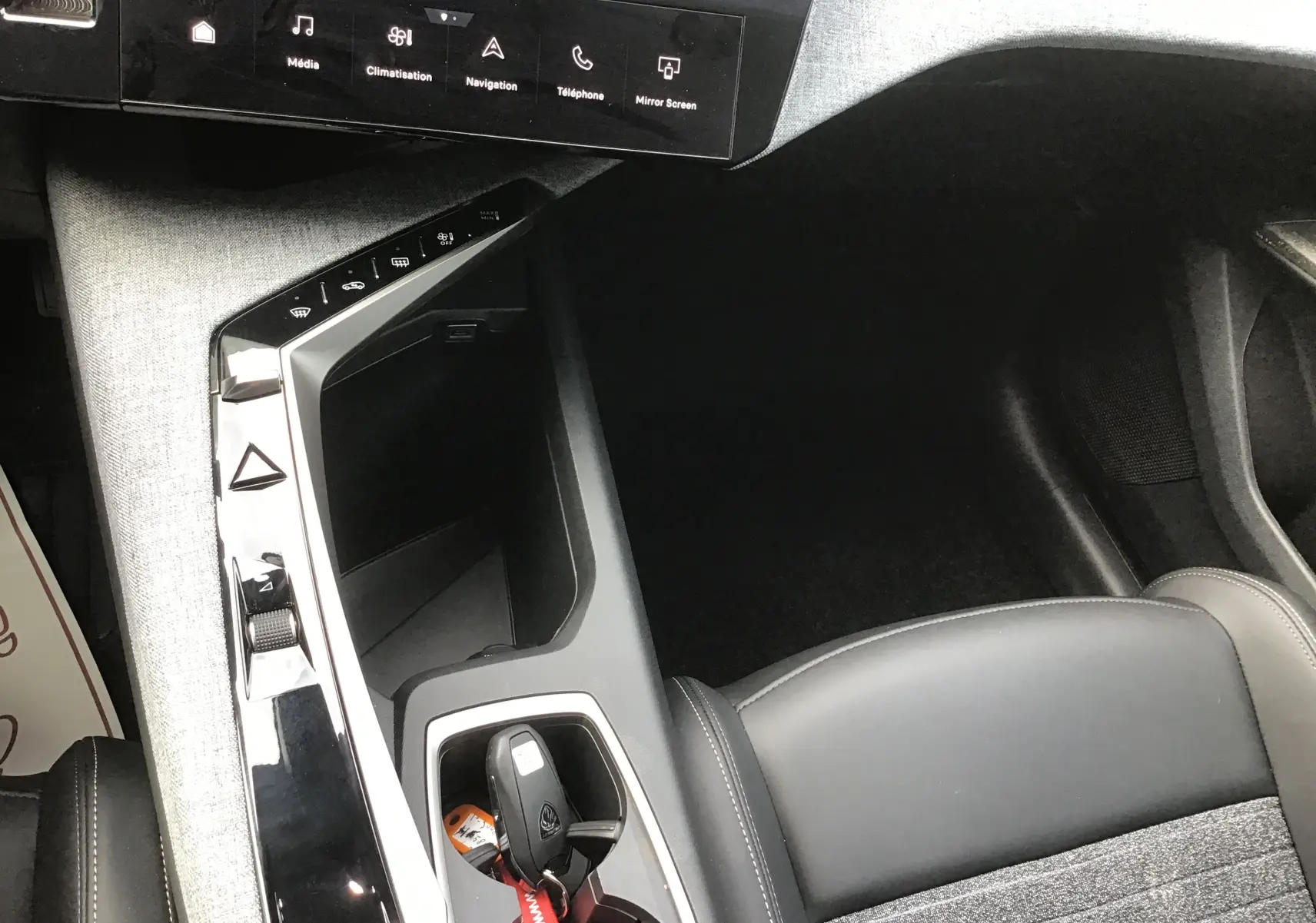 Vue intérieure rapprochée du coffre à clés et console centrale du Peugeot 3008 gris, avec écran tactile et sellerie cuir.