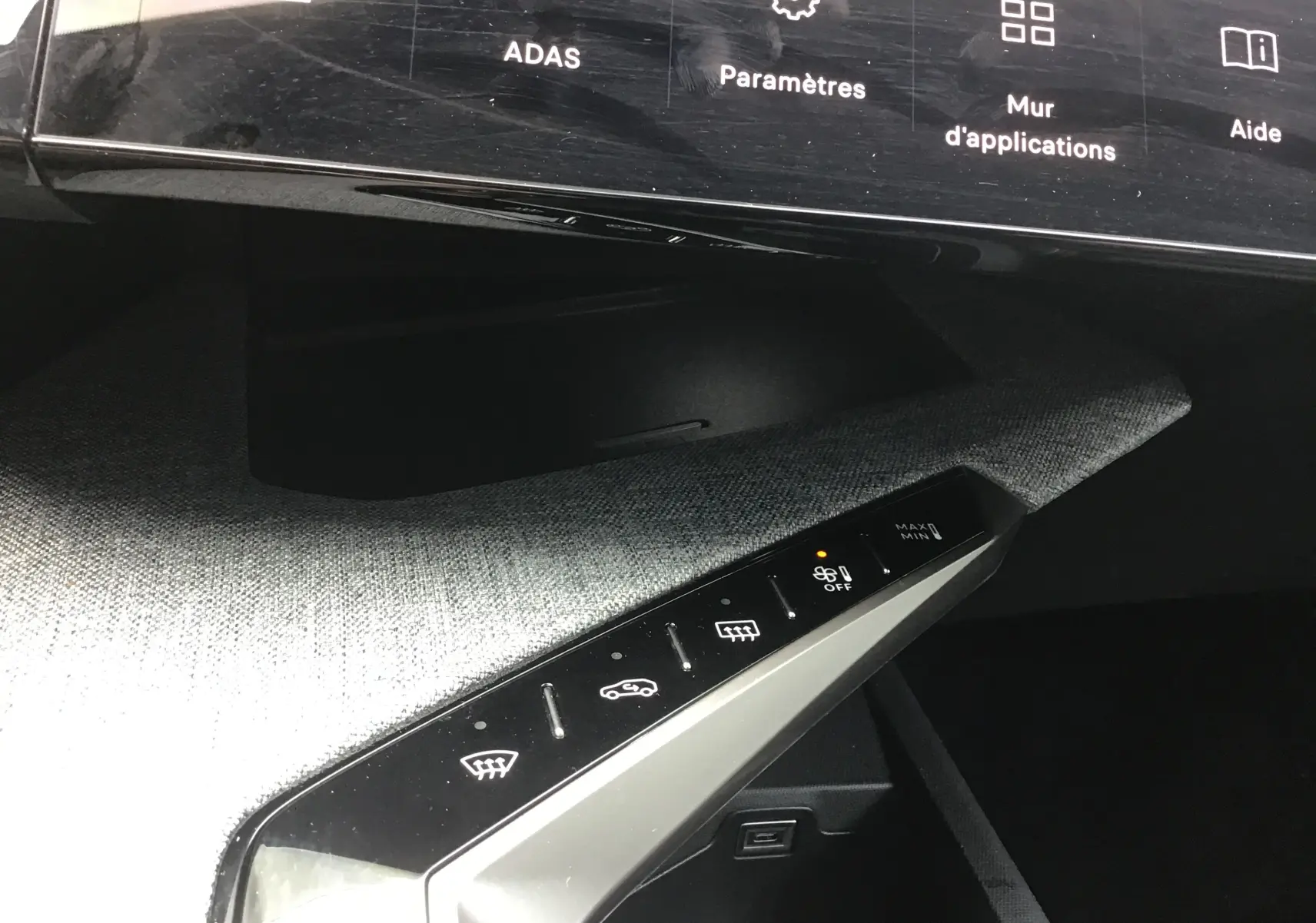 Vue rapprochée du tableau de bord du Peugeot 3008 1.2 Hybrid 145 Allure, montrant les commandes de climatisation sur fond gris Artense.