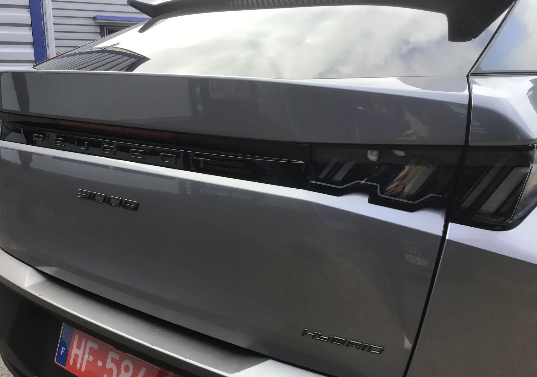 Vue arrière en gros plan du Peugeot 3008 gris Artense avec logo et feux arrière noirs distinctifs.