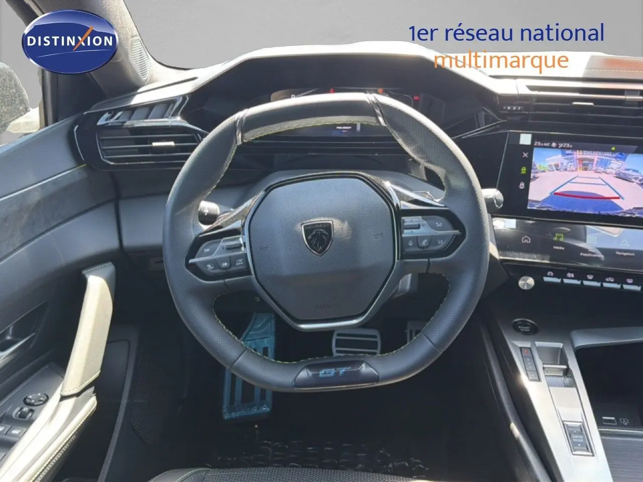 Vue intérieure centrée sur le volant cuir noir et le tableau de bord digital de la Peugeot 308 Hybrid 145ch GT 2026.