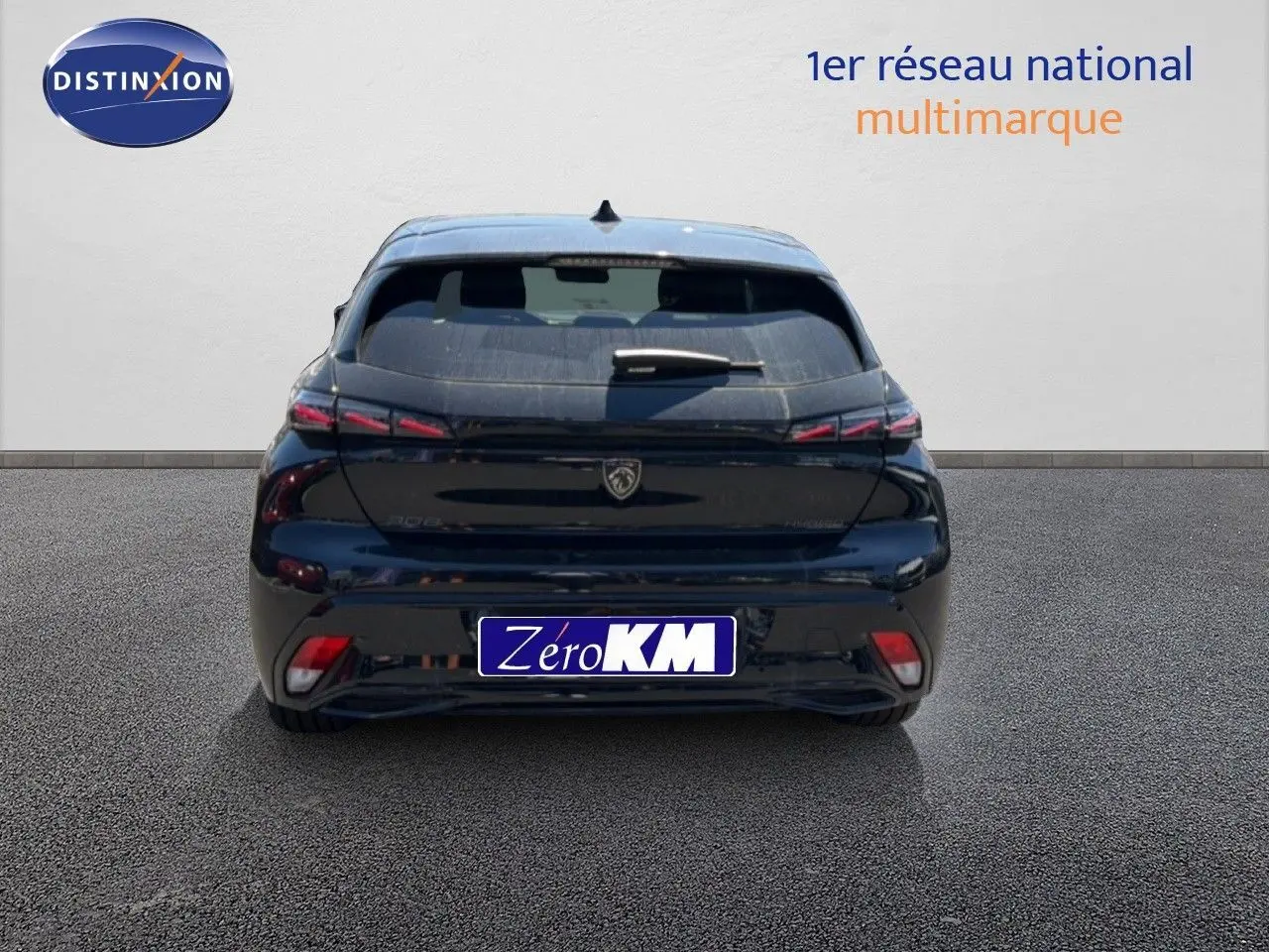 Vue arrière d’une Peugeot 308 Hybrid 145ch GT noire perle métal, avec feux arrière LED et logo lion central.